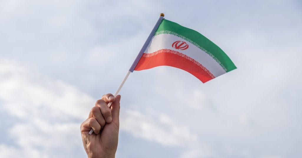 The national flag of the Islamic Republic of Iran, the national emblem ("Allah") in red centred on the white band and the takbir.